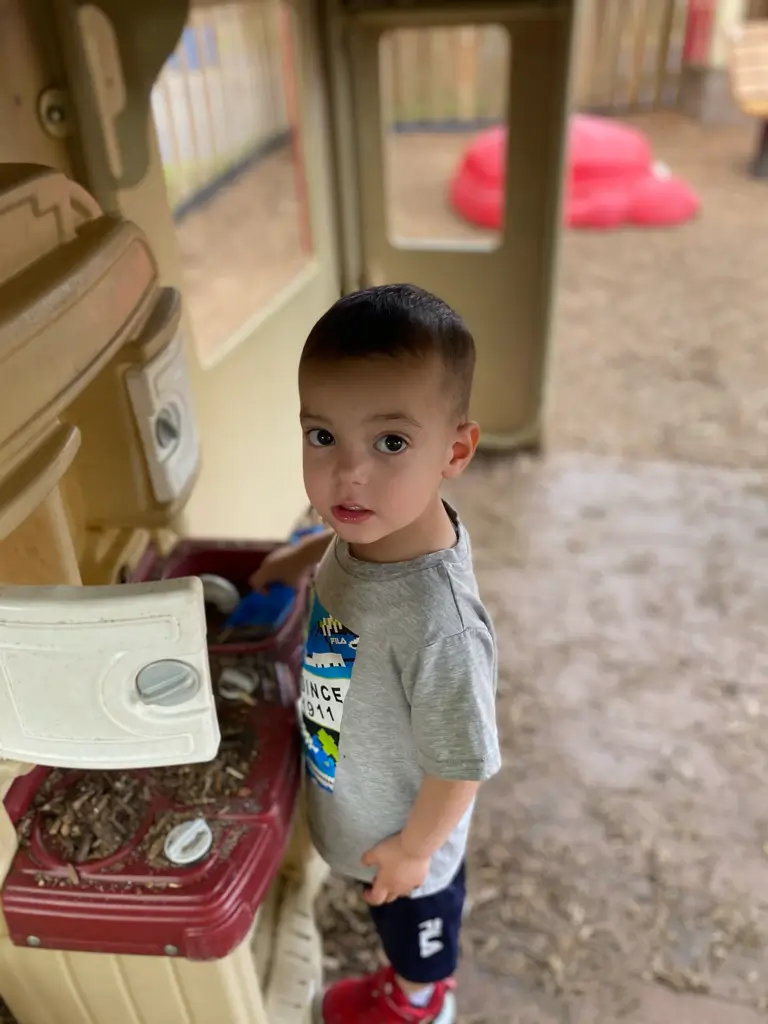 Child playing in outdoor play kitchen.